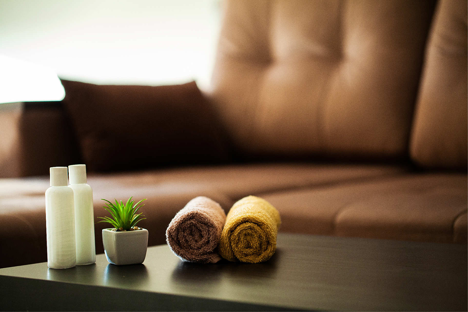 Två handdukar på ett bord vid en soffa. 